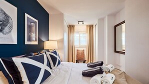 A hotel room with a bed, a chair, a lamp, and a mirror. - Beachfront Conquistador (El Campello)