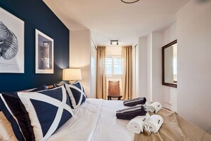 A hotel room with a bed, a chair, a lamp, and a mirror. - Beachfront Conquistador (El Campello)