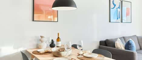 Comedor con una mesa preparada para dos, una botella de vino y dos copas.
