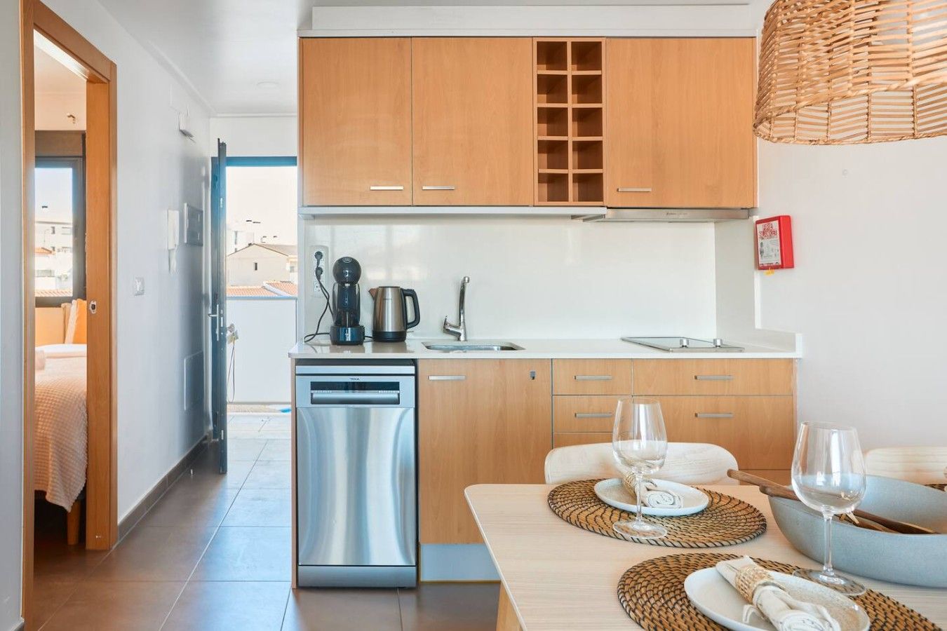 Eine moderne Küche mit Edelstahlgeräten, Holzschränken und einem Essbereich mit Tisch für zwei Personen.