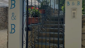 A gated entrance with "B&B" signage and a decorative arch above. - Capri Melody  (Anacapri)
