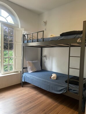 A bunk bed room with a window, a white wall, and a wooden floor. - Aurora Hostel Rio (Rio de Janeiro)