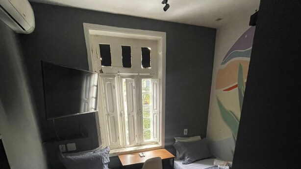 Una habitación pequeña con dos camas individuales, un escritorio y una silla.