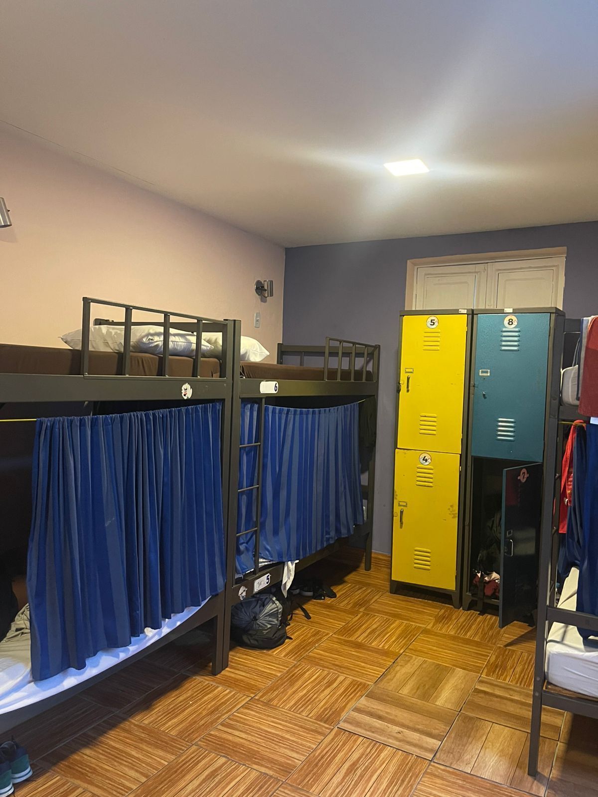 Un dormitorio con literas, un armario y taquillas.