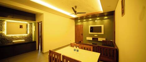 Una cocina moderna con comedor, muebles de madera y televisor integrado.