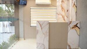 Un área de recepción con paneles de pared de mármol, un televisor montado y un equipo de aire acondicionado.