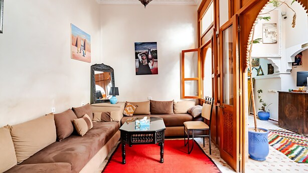 A living room with a sofa, a coffee table, and a red rug. - darjenanadam (Marrakech)