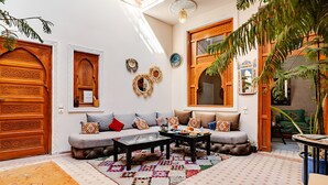 A cozy living room with a sofa, coffee table, and decorative rugs. - darjenanadam (Marrakech)