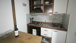 A compact kitchen with a gas stove, sink, and wooden cabinets. - Kevisco House is in the center of Rome very cozy equipped with all the comforts (Roma)