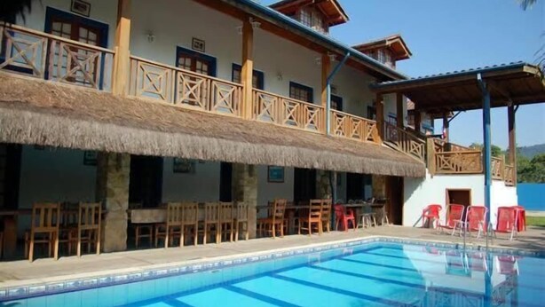 A hotel with a pool, outdoor seating, and a thatched-roof structure. - Pousada Aqui é Parati  (Paraty)