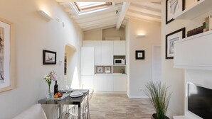 A modern interior with a dining area, kitchen, and living space. - Strozzi Terrace View (Firenze)