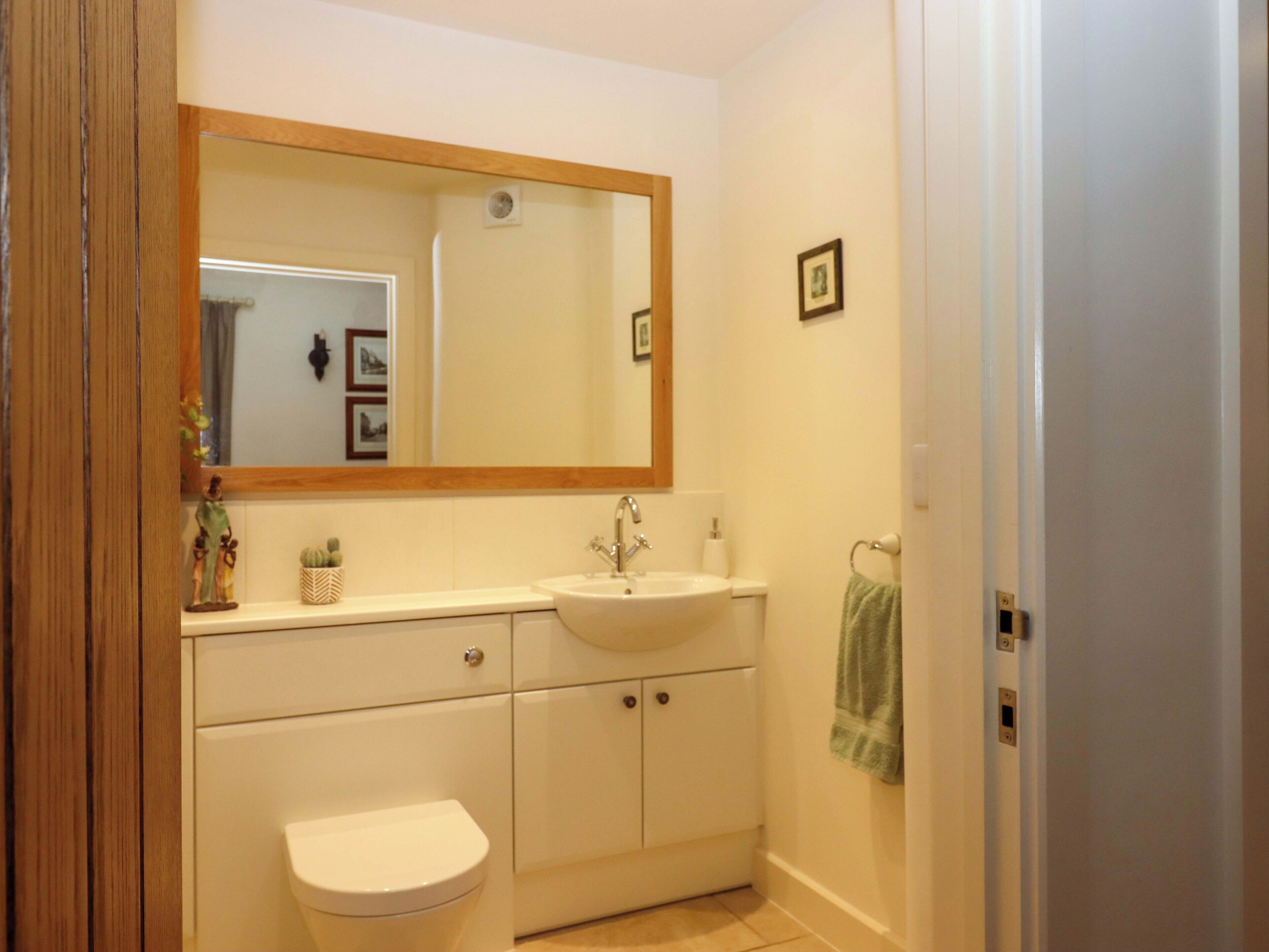 Ein Badezimmer mit Waschbecken, Spiegel, Toilette und Schrank.