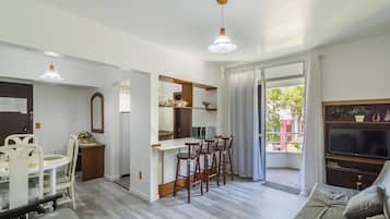 Una cocina moderna con comedor, una barra pequeña y un sofá.