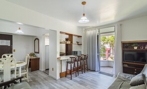 A modern kitchen with a dining area, a small bar, and a sofa. - 1-bedroom Apt in Blumenau Spn0102 (Blumenau)