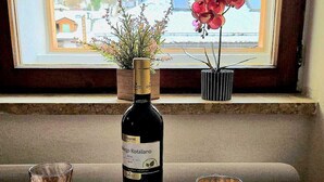 A dining table with a bottle of wine, two glasses, and a plate set for two. - Maison Cavalese - Polar Express - Intimacy in the center of town (Cavalese)