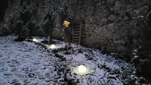 A snow-covered outdoor area with stone walls and a wooden ladder. - Maison Cavalese - Polar Express - Intimacy in the center of town (Cavalese)