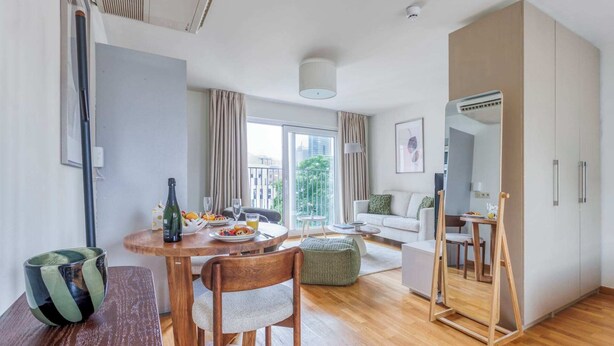 Un salon moderne comprenant un coin repas, un canapé, une table basse et un grand miroir.