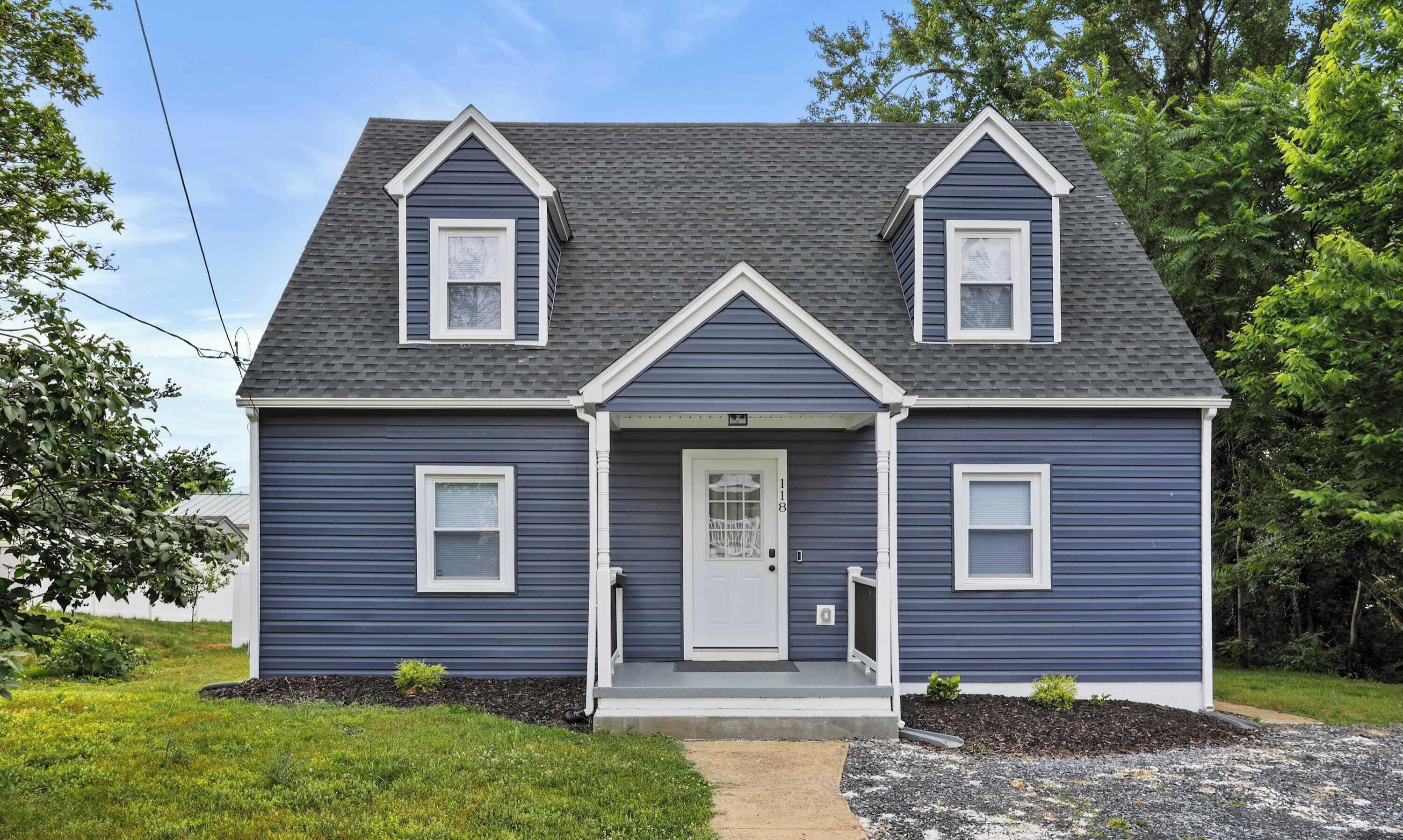 A two-story house with a front porch and a mailbox.