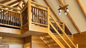 Un interior de madera con zona de comedor, escalera y una puerta.