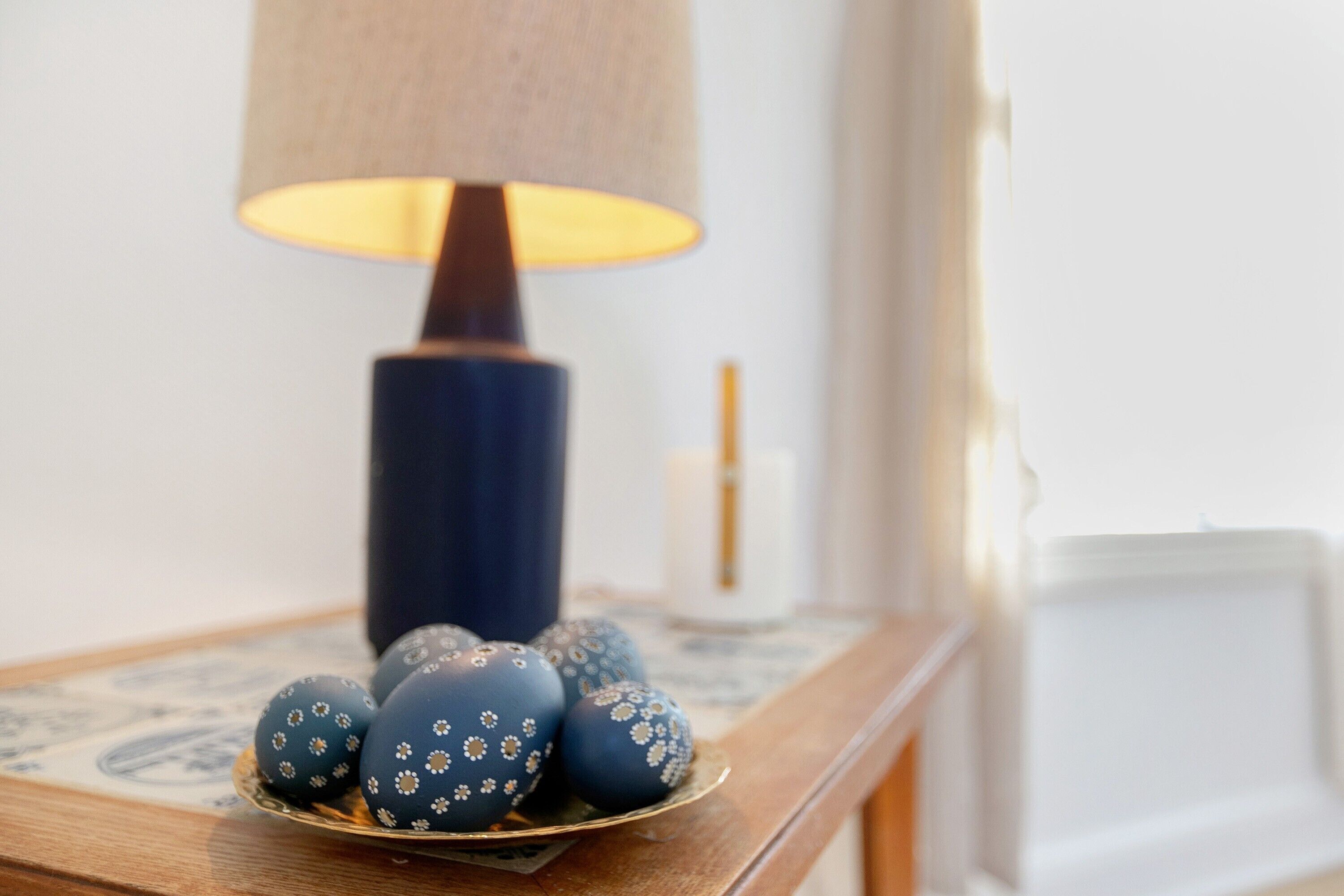 Ein Tisch mit einer blauen Lampe und dekorativen Eiern.