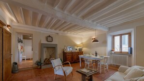 Ampla sala de estar com lareira, mesa de jantar e um ambiente acolhedor.