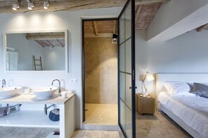 A modern bathroom with a large mirror, two sinks, and a shower area. - Tenuta Pomona (Cortona)