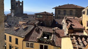 A historic town with stone buildings, a clock tower, and terracotta roofs. - Casa Ada e Sabo (Cortona)