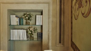 A bookshelf with books and vases of flowers. - Casa Ada e Sabo (Cortona)