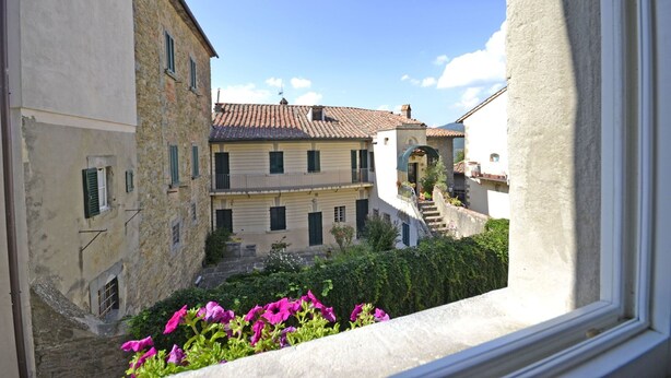 Eine enge Straße mit Steinhäusern, einer sichtbaren Treppe und einem Fenster mit Blick auf die Straße.