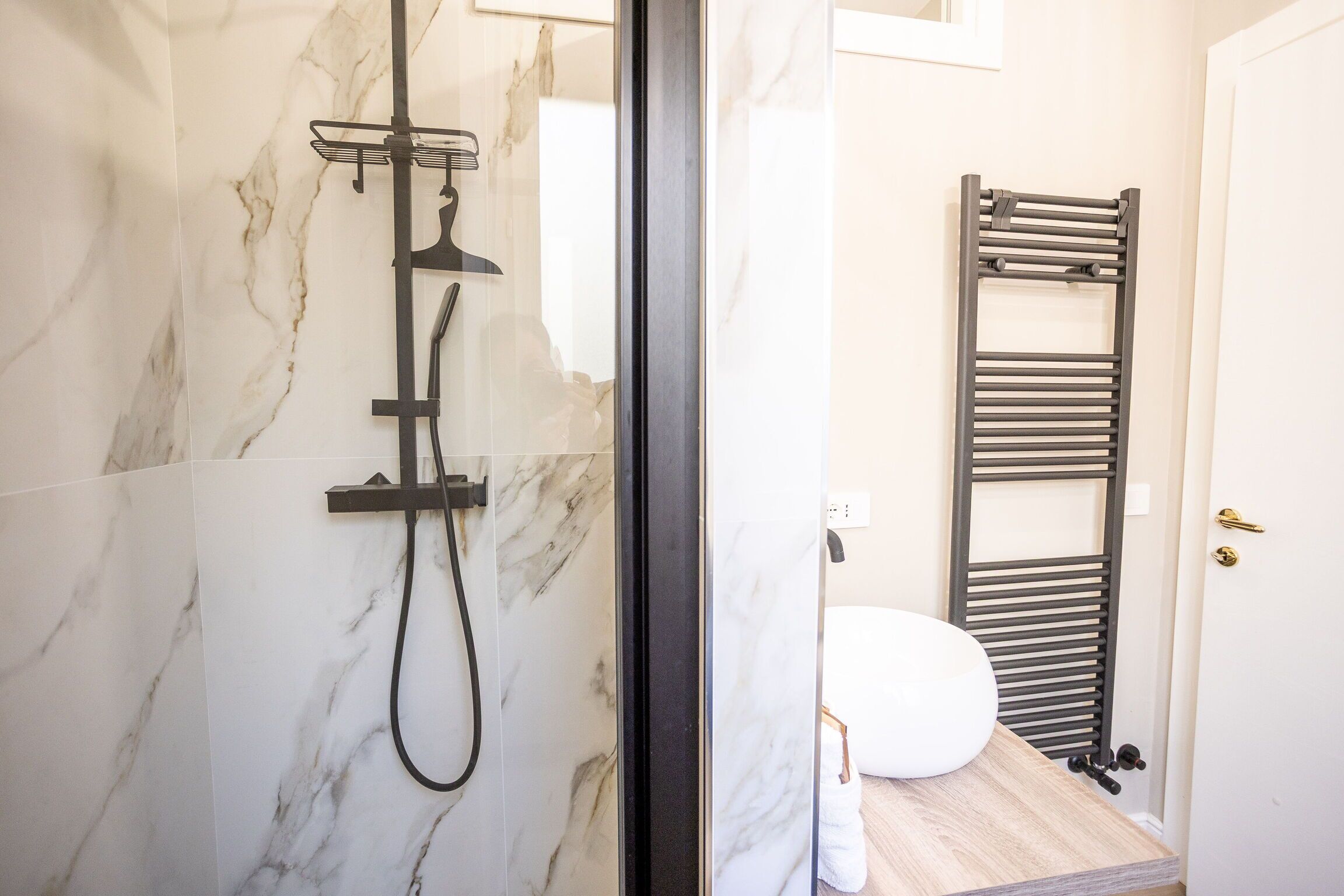 A bathroom with a shower, a towel rack, and a toilet.