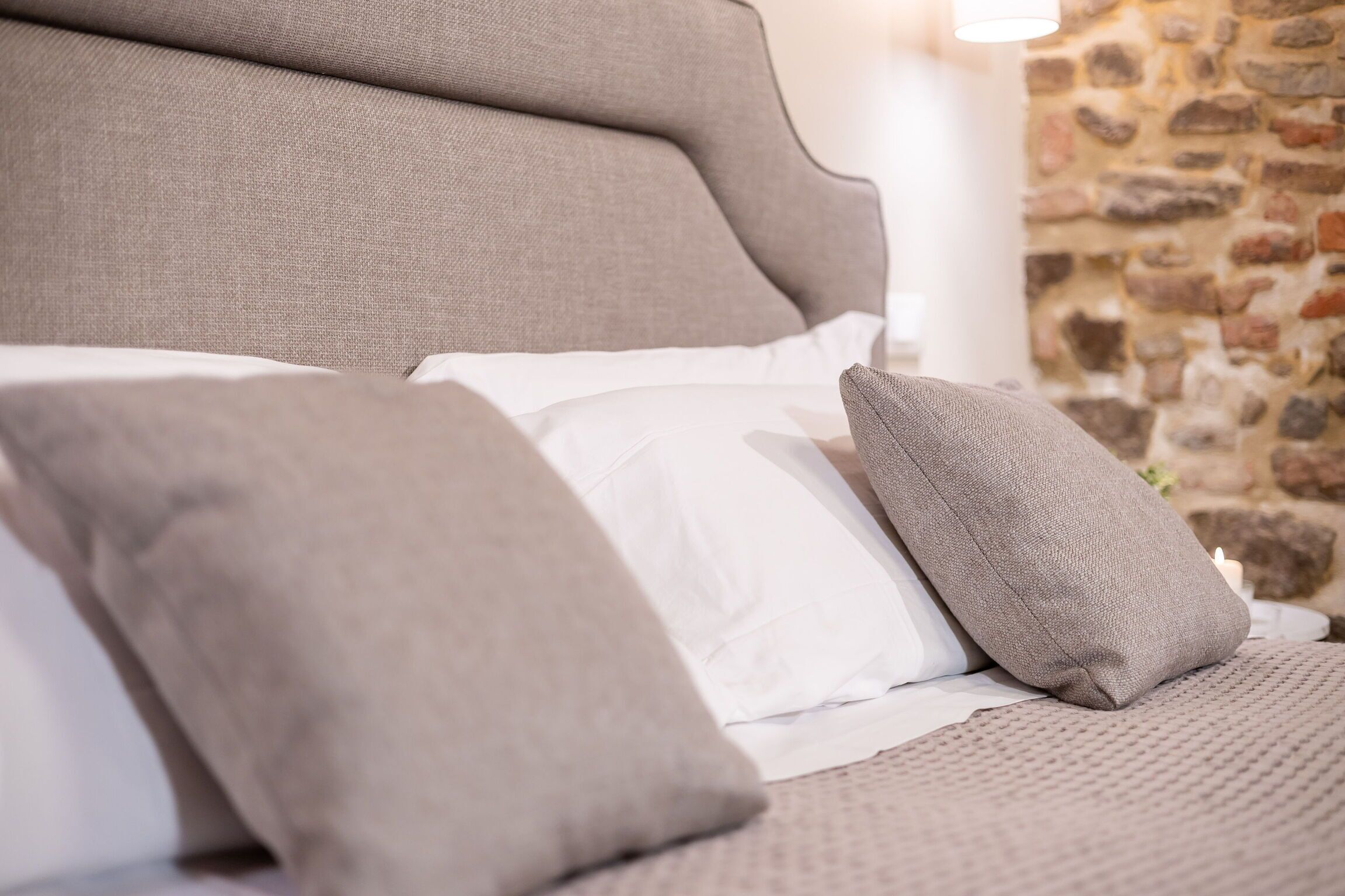 A bed with a headboard, pillows, and a blanket.