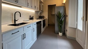 Una cocina moderna con armarios blancos, un grifo negro y un horno empotrado.
