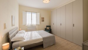 A bedroom with a bed, a chair, a wardrobe, and a window. - Casa Maria (Cortona)