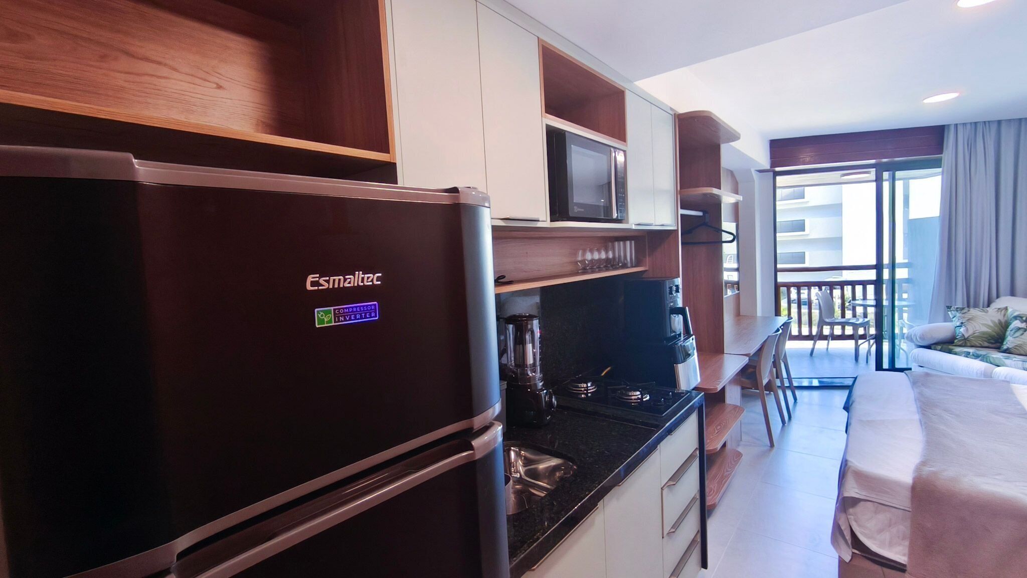 A compact kitchen with a refrigerator, microwave, and stove.