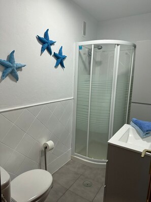 Ein Badezimmer mit Toilette, Dusche und Waschbecken.
