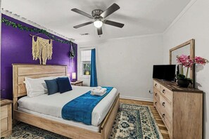 A bedroom with a bed, a wooden dresser, a ceiling fan, and a window with curtains. - Furnished 3BR Near Folly Beach | Yard + Ping Pong (Charleston)
