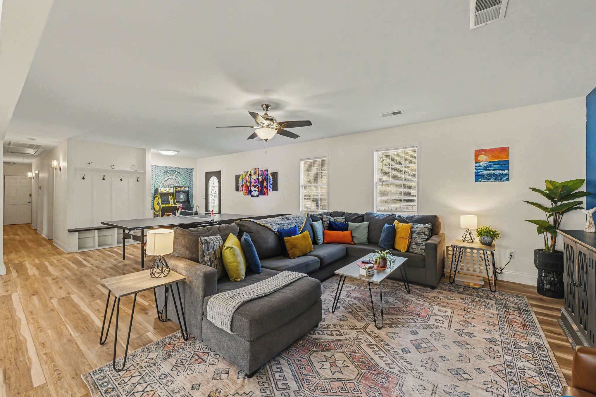 A modern living room with a sofa, coffee table, and a gaming table.