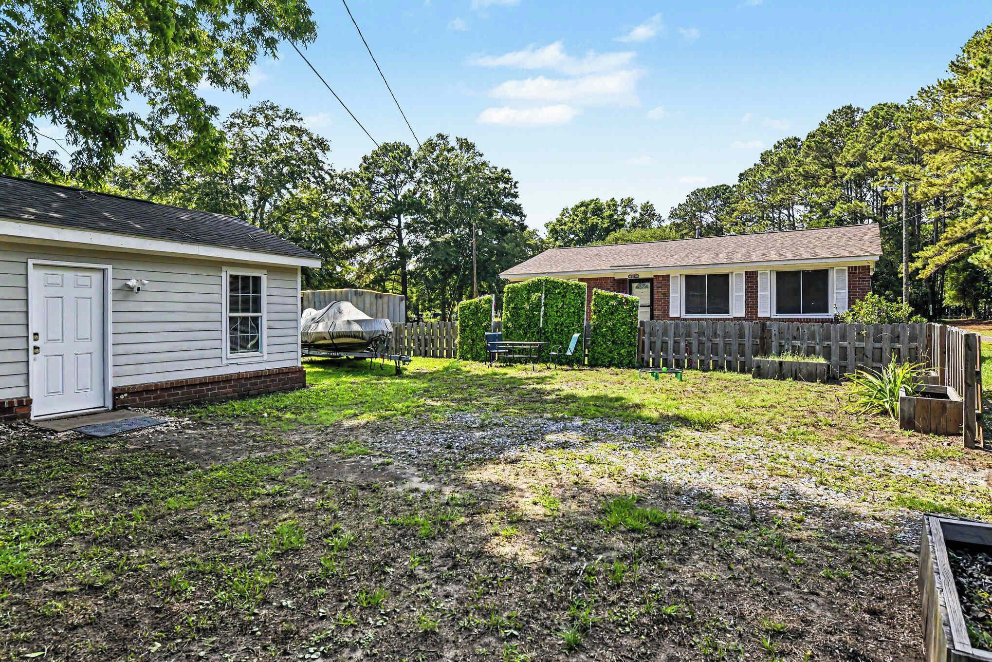 A residential property with two detached houses, a fenced yard, and a small garden area.