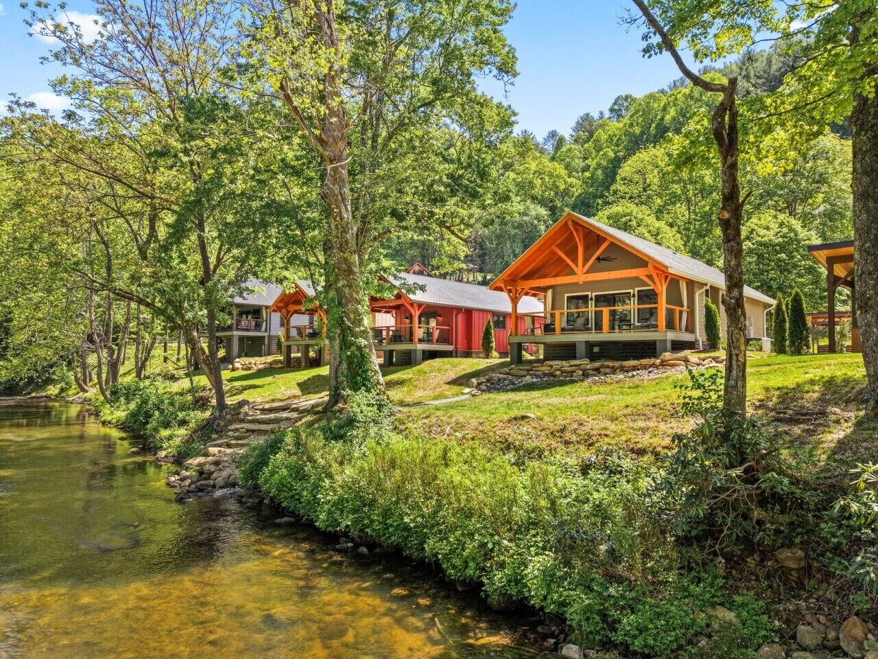 Ein Seehaus mit mehreren Blockhütten, einem Steinpfad und üppiger Vegetation.