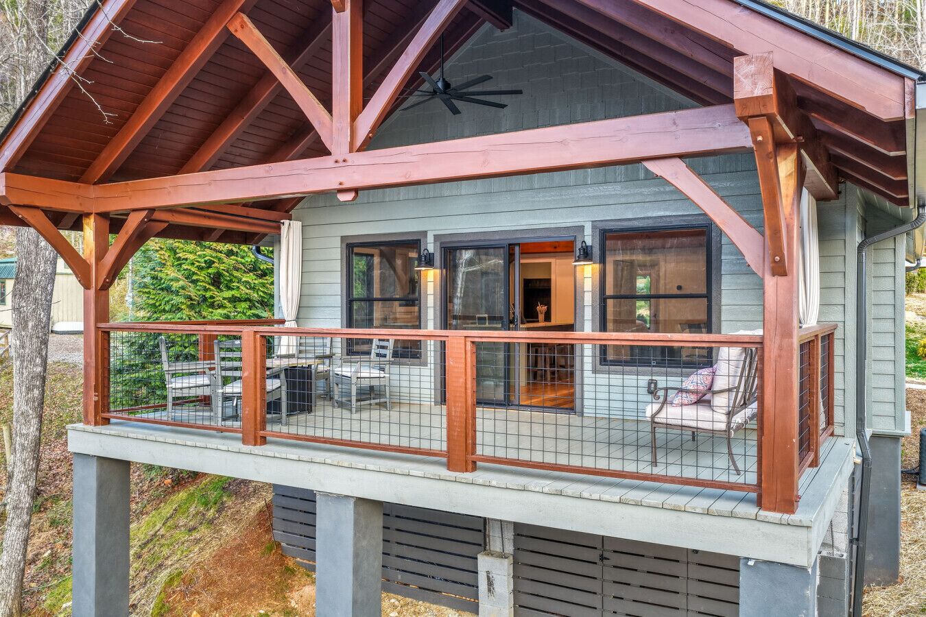 A two-story house with a covered porch and a fenced deck.