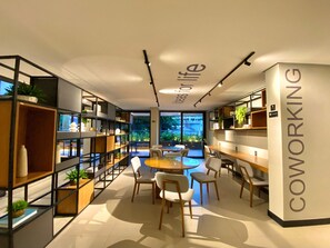 Ein moderner Coworking-Space mit offenen Regalen, einem zentralen Tisch und Stühlen.