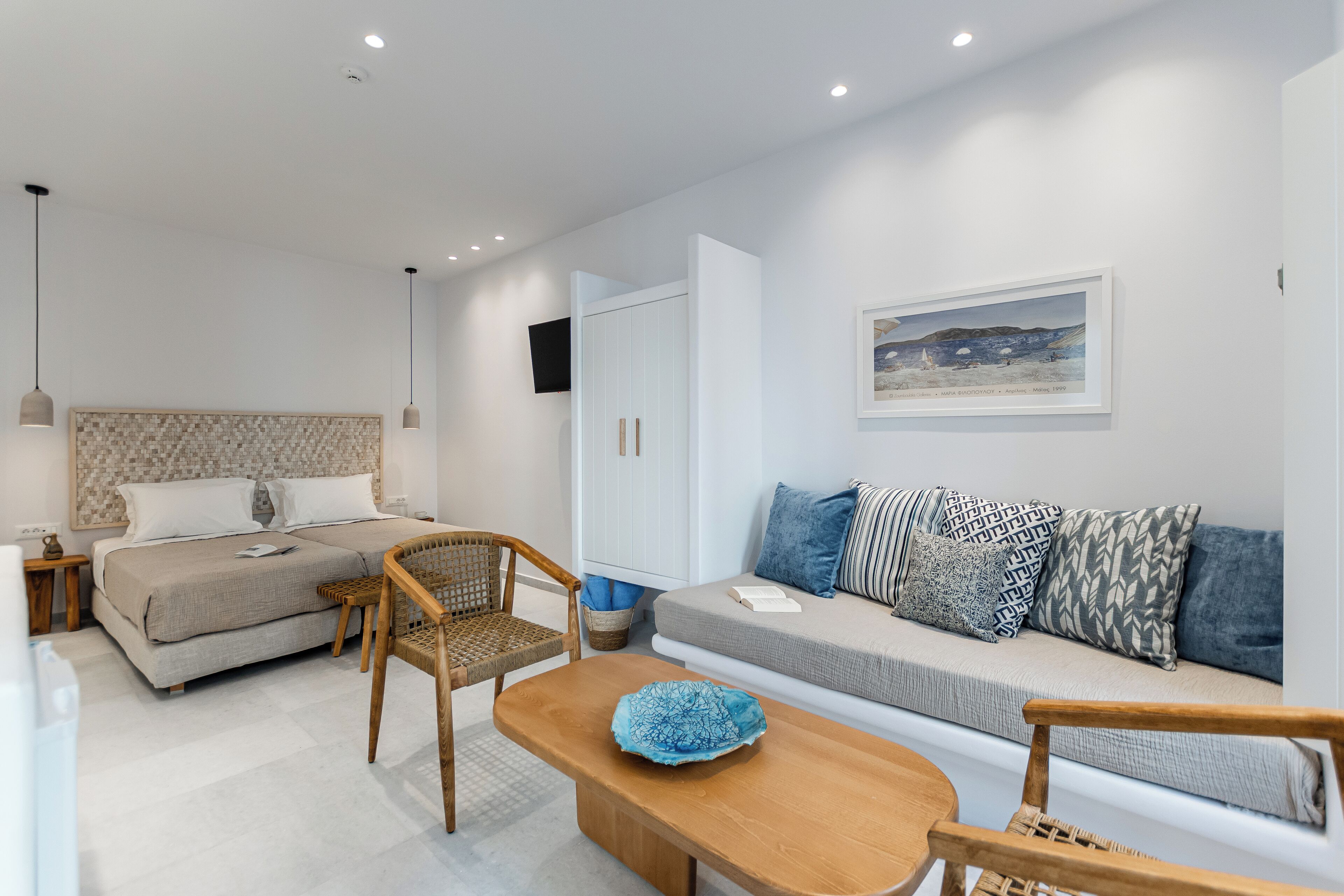 Een moderne slaapkamer met een bed, twee nachtkastjes, een houten stoel, een bank en een salontafel.