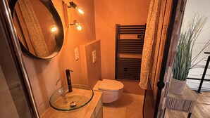 A compact bathroom with a glass sink, a toilet, and a mirror. - The little refuge (Quimperlé)