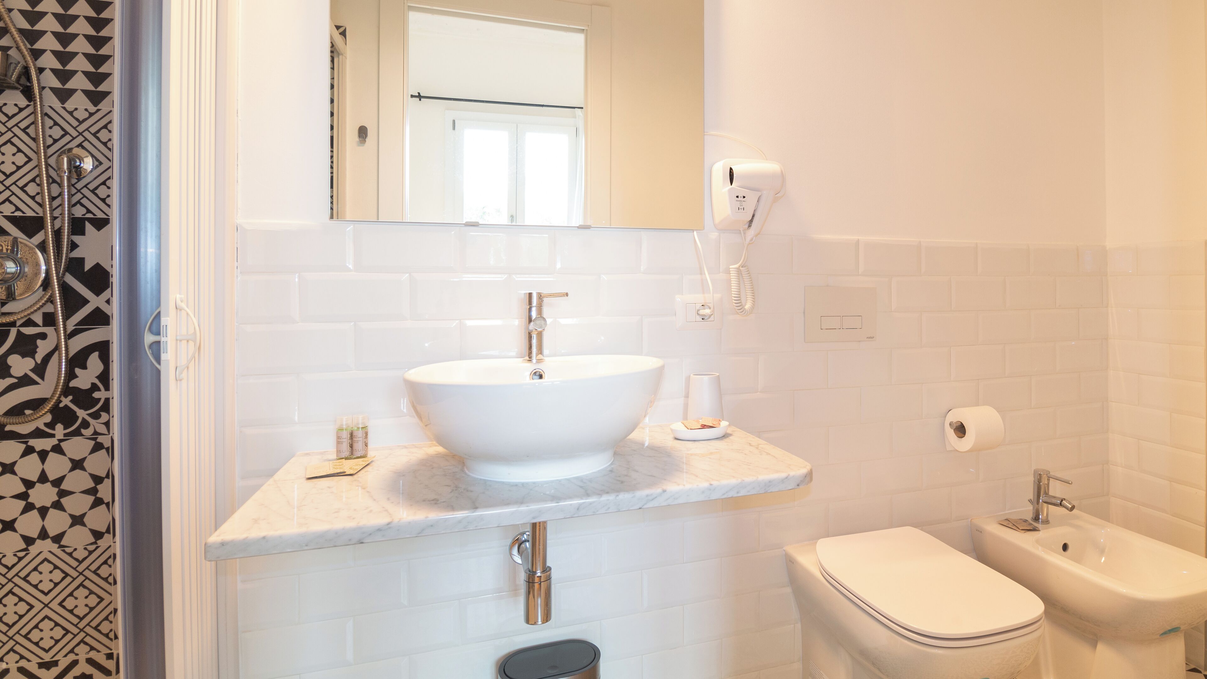 Un baño con lavamanos blanco, inodoro y ducha.