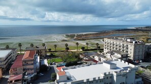 A coastal hotel with multiple floors, a parking area, and a view of the beach and ocean. - AB-apartHotel (Gizzeria Lido)