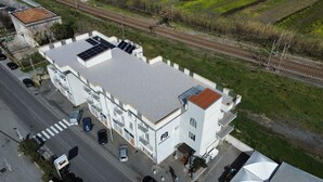 Un edificio moderno con tetto piano, ampie finestre e un parcheggio.