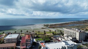 A coastal view with a beach, buildings, and a clear sky. - AB-apartHotel (Gizzeria Lido)