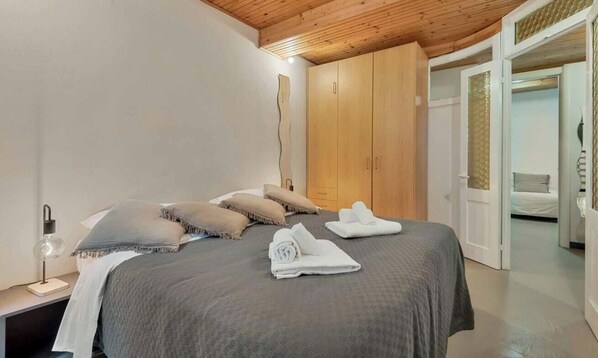 A bedroom with a bed, pillows, a nightstand, a lamp, and a wardrobe. - Welcome to La Grotta, an extraordinary holiday home located in the picturesque village of Vernazza.This charming home takes its name from a unique and fascinating feature: a real cave inside the house! La Grotta offers an unforgettable stay experienc (Vernazza)