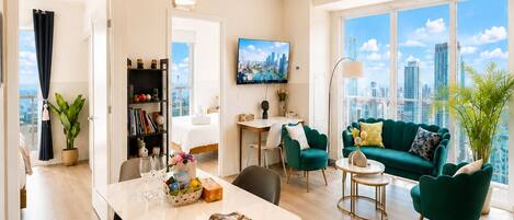 A modern living room with a dining area, a sofa set, and a city view.