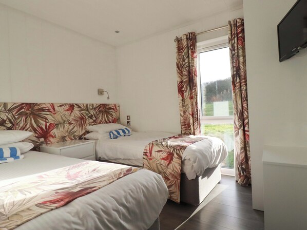 A hotel room with two beds, a window with curtains, a flat-screen TV, and a nightstand. - South Crofty - The Residence (Redruth)